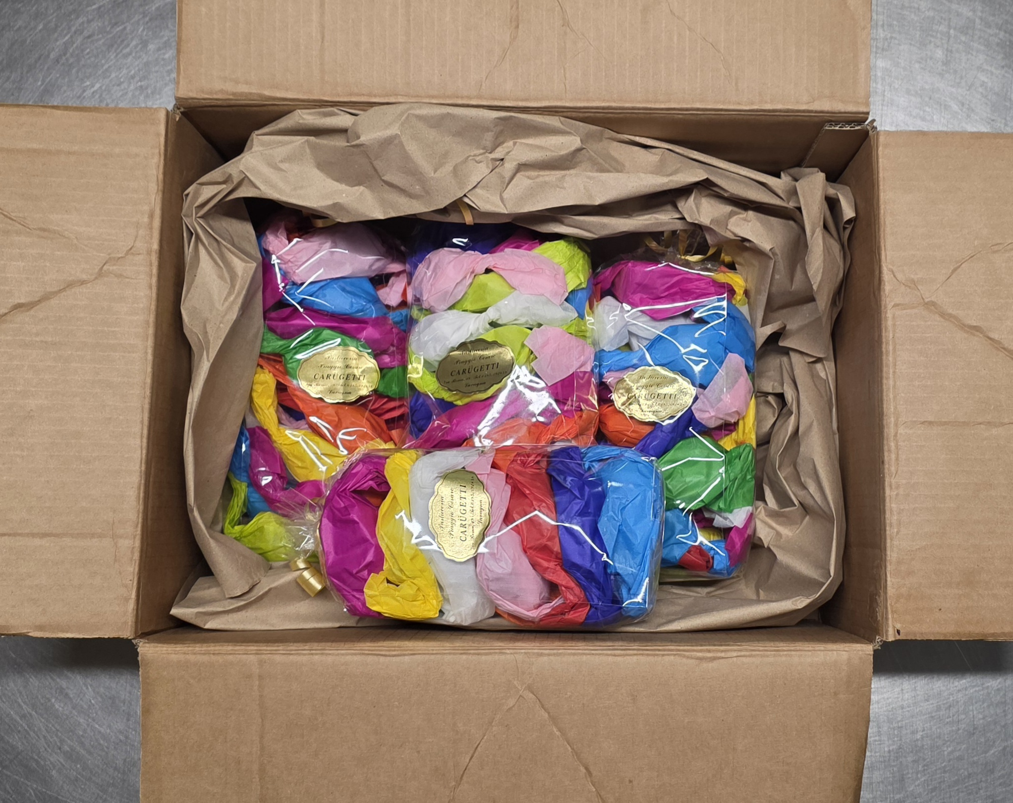 Foto di un imballagigo classico dei carugetti, con all interno due confezioni avvolte con un imballo protettivo di carta.